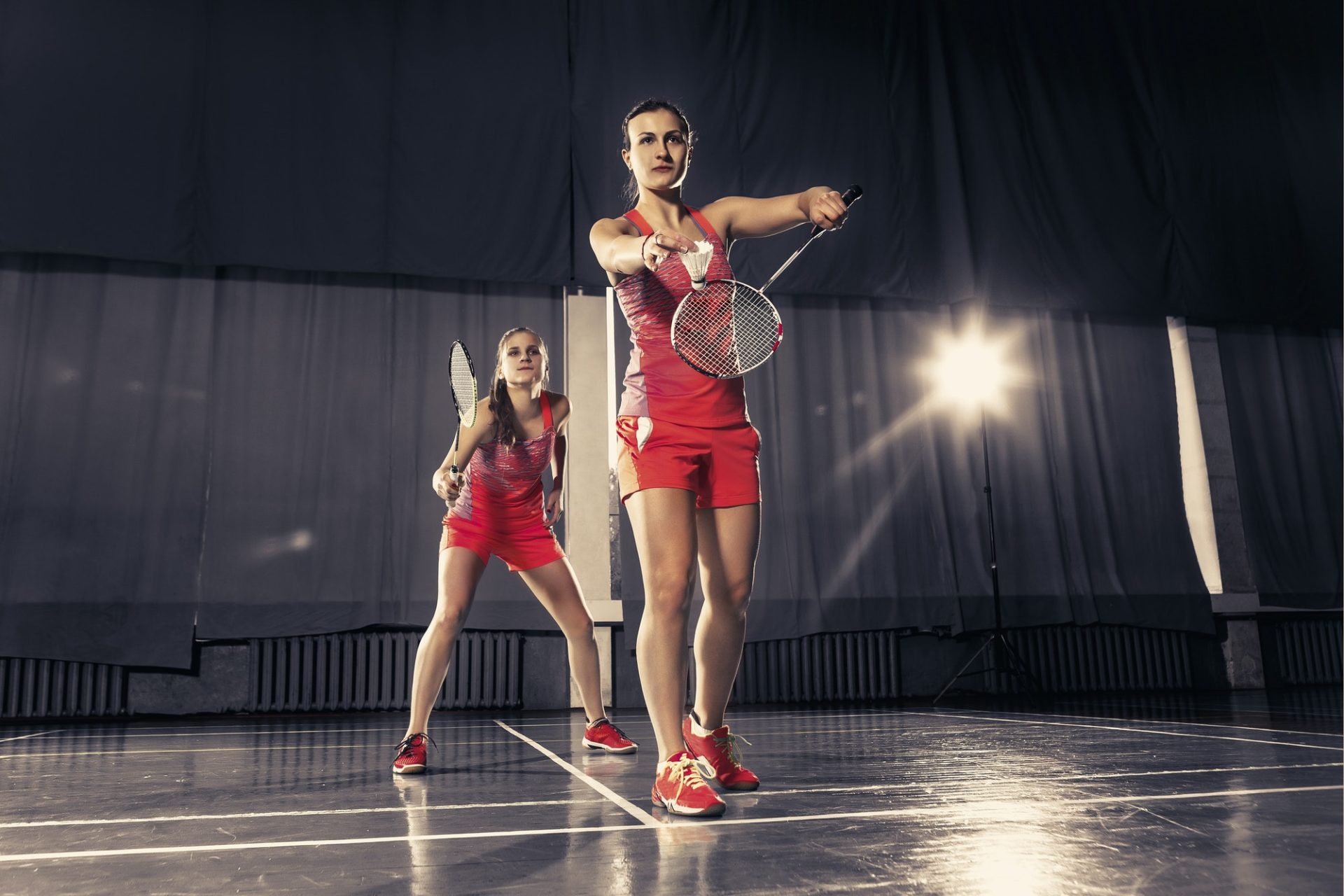 young-women-playing-badminton-at-gym-1-e1657173703217.jpg